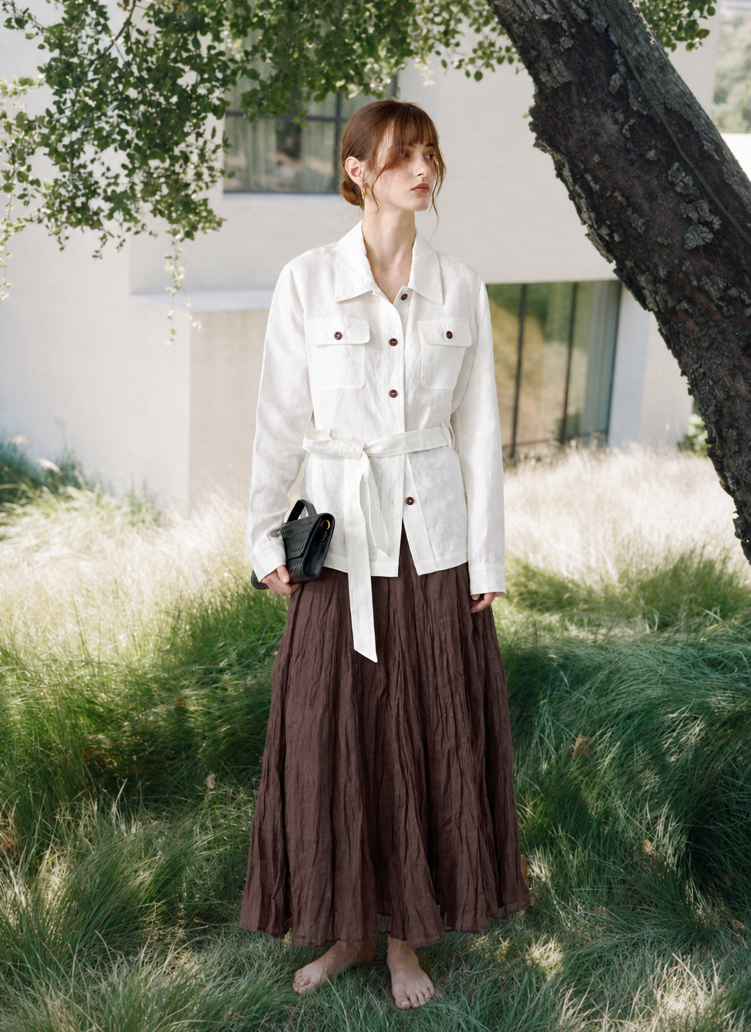 The Linen Edit — white belted linen jacket and brown skirt in a garden